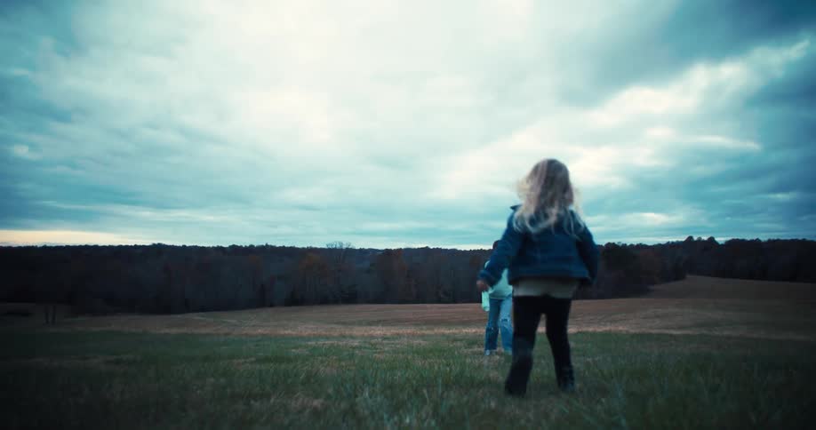 Two girls play with their dog on the farm