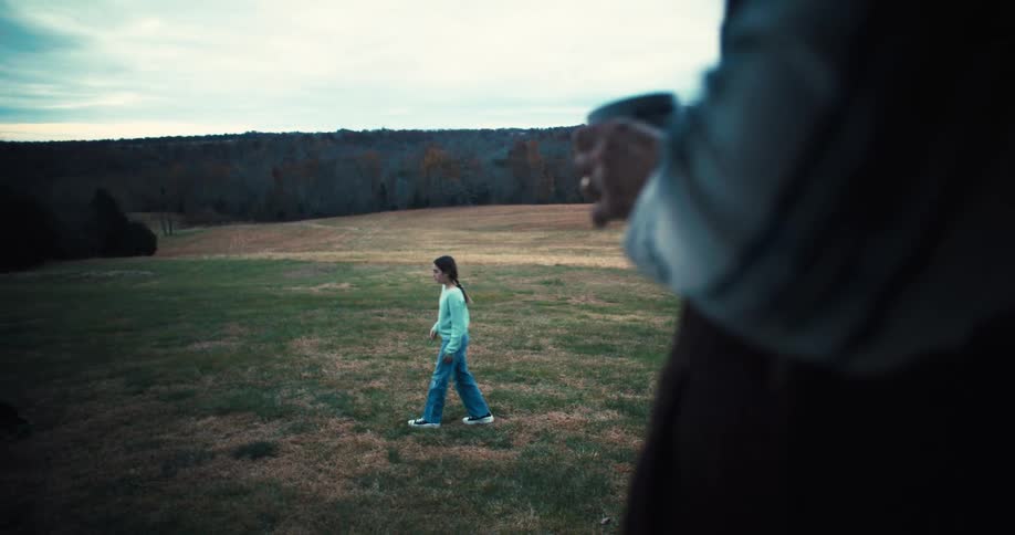 A girl is playing fetch with her dog on the farm