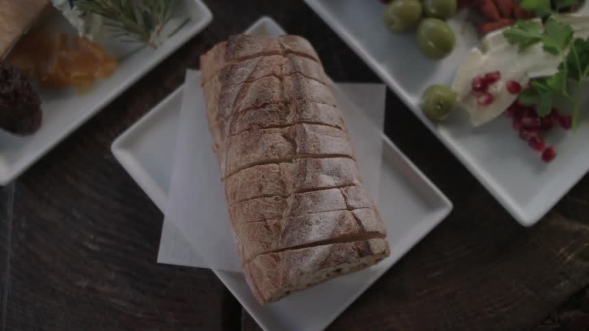 A loaf of bread is cut on the plate below