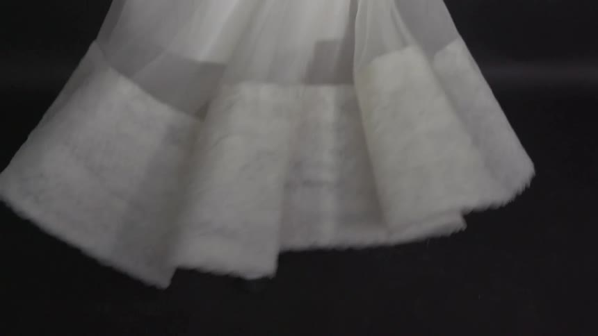 A woman dressed in white turns as her skirt twirls
