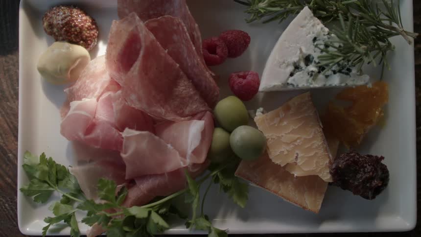 Meats and cheese sitting on white plate