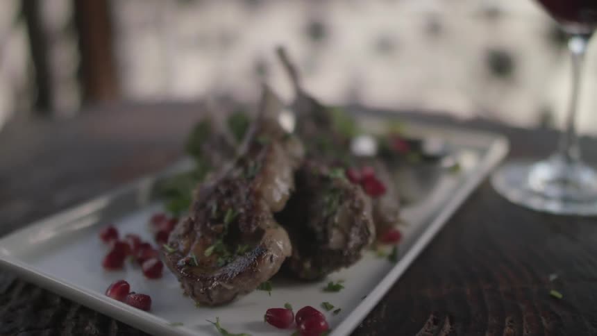 Plated food sits near a glass of red wine