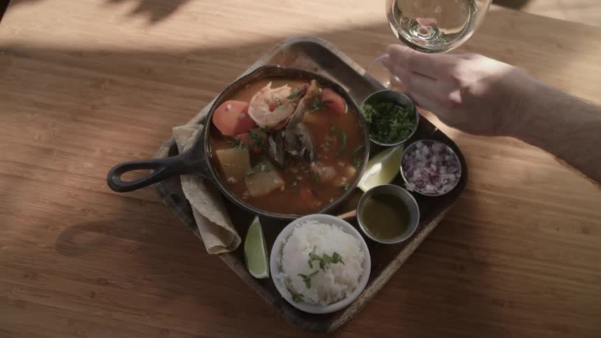 A glass of white wine is placed next to plated food