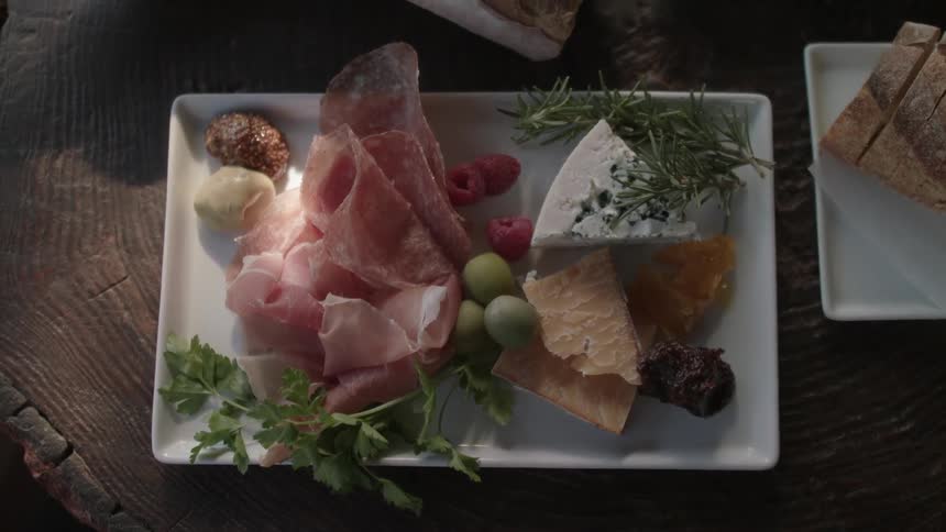 Meats and cheeses sitting on white plate
