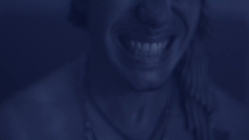 Closeup of a smile with necklaces and a striped scarf visible