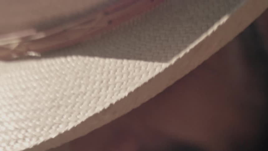 A man wearing a straw hat works outdoors