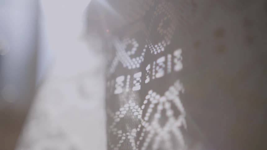 Light shines through a lacy fabric