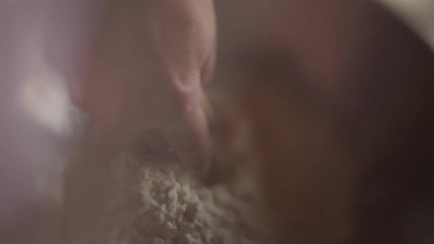 An adult and young child stir flour