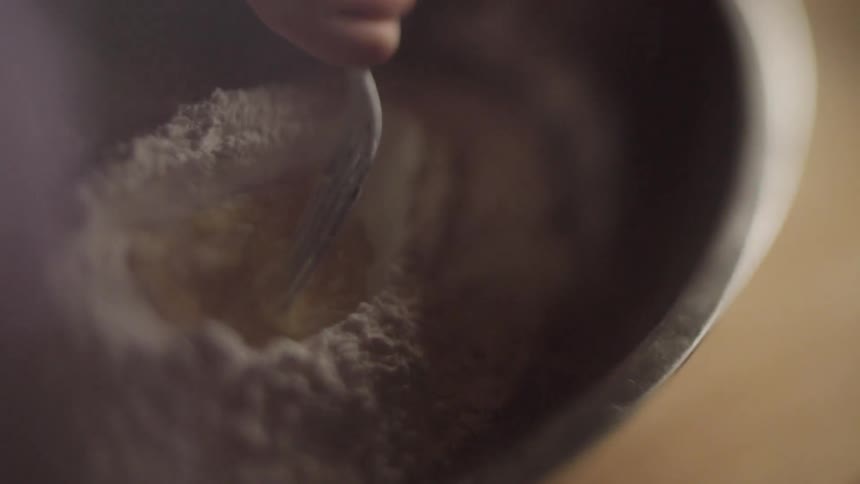 A child stirs flower in a bowl