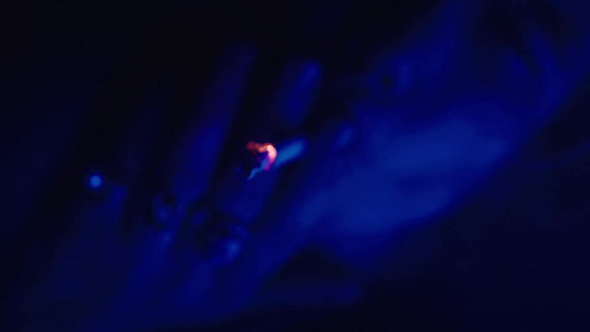 Person smoking under deep blue lighting