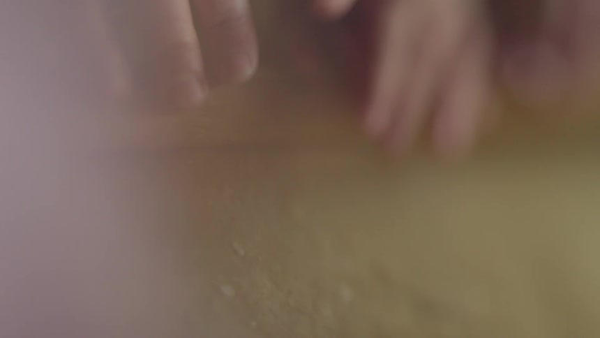Person and child using rolling pin to flatten dough