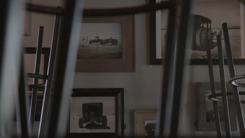 Framed pictures of old cars on wall inside building