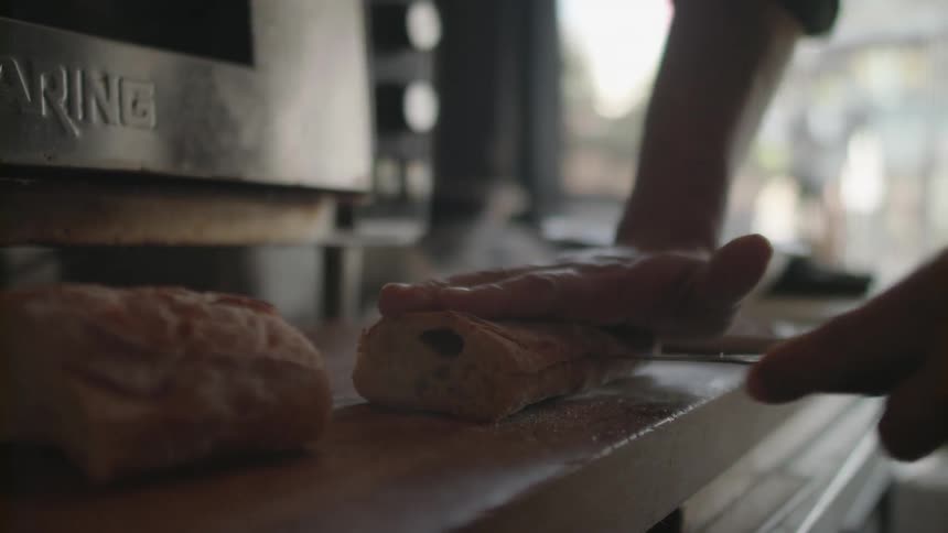 A man slices a piece of bread
