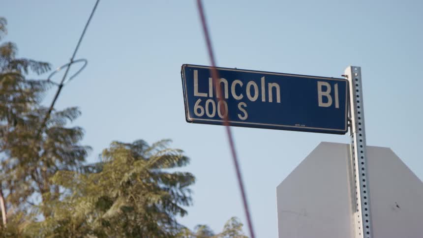 A lincoln boulevard sign is hanging from a street corner
