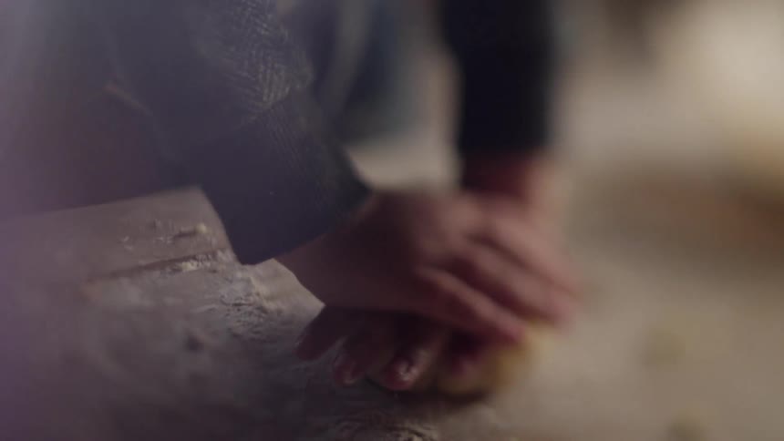 A person pushes down on a ball of dough