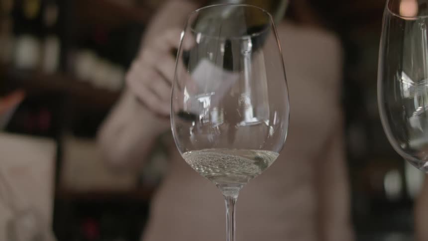 White wine is poured into a wine glass