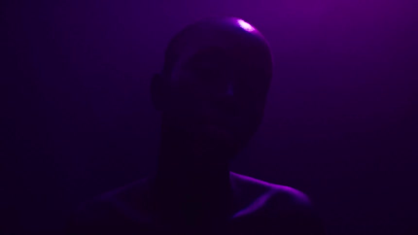 Silhouette of a woman illuminated by soft purple light