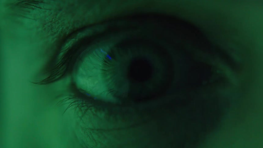 An extreme closeup of a human eye under lighting