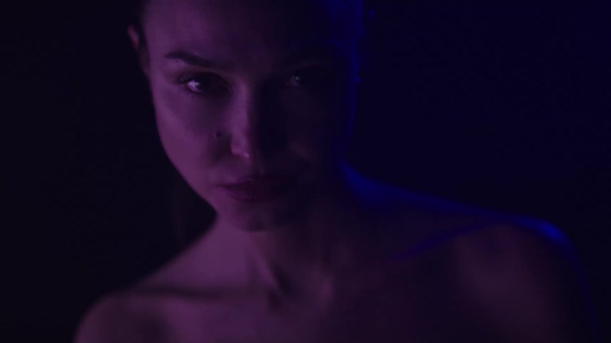 The woman is standing in the dark blinking