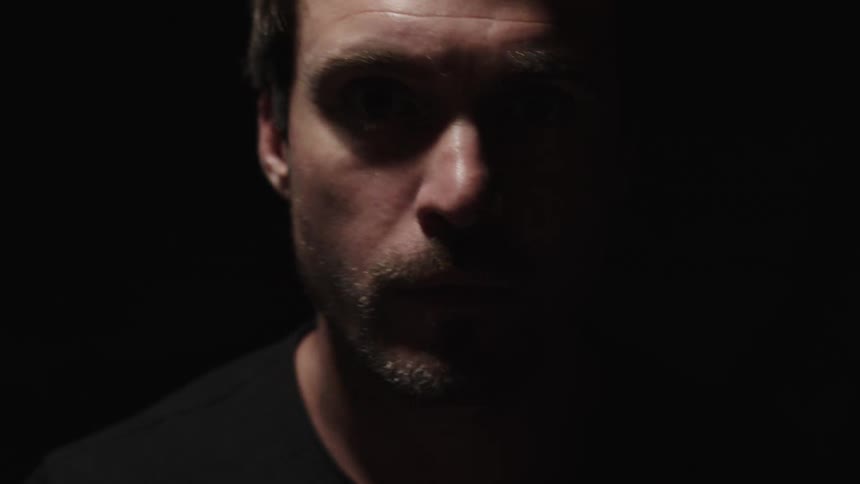 The man is moving forward in the dark room