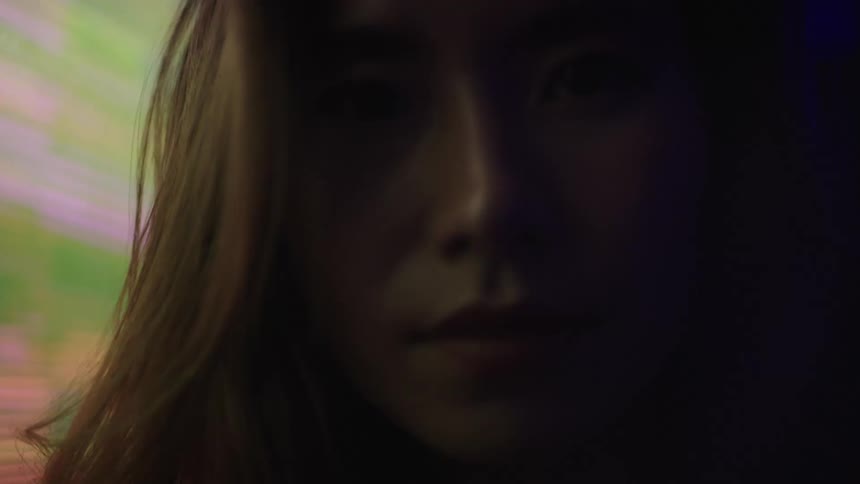 A softly lit neon portrait of a woman in purple light