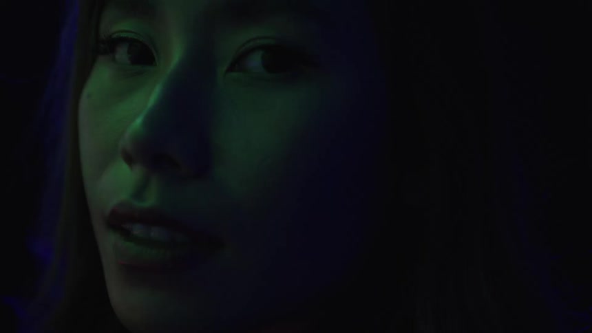 The woman is smiling under the strobe lights