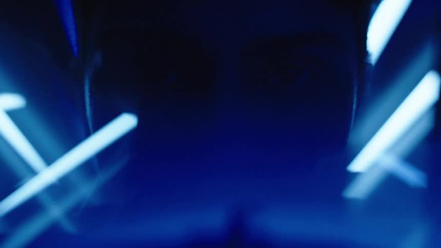 Shadowed face surrounded by blue light beams