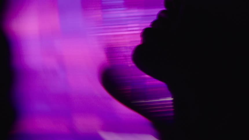 Human profile silhouette against moving colorful lights