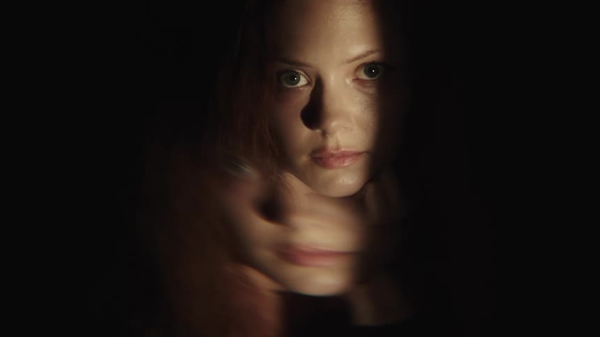The light is shining on the womans face as she blinks