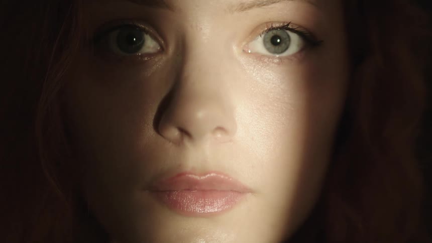 A closeup of a womans face with some makeup with her eyes the main focus