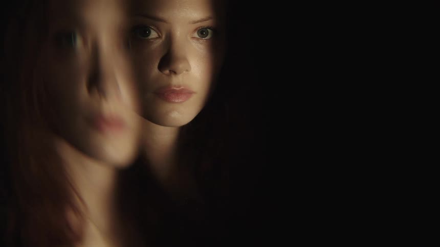 The womans face is mirrored in the dark