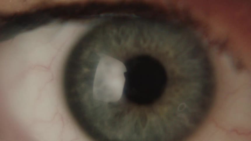 Extreme close up of a blue eye blinking