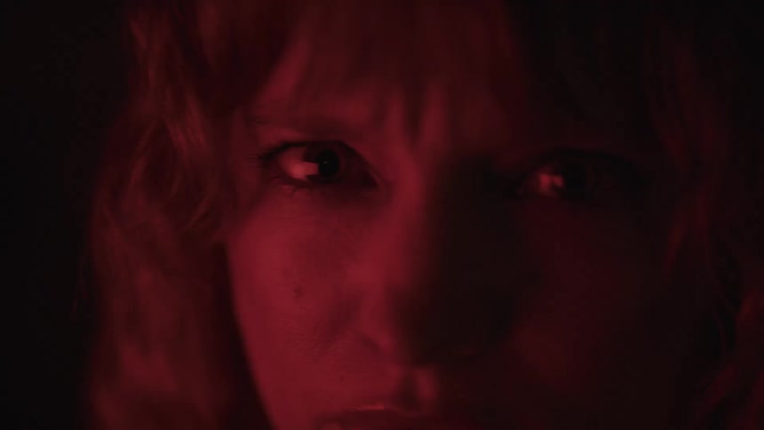 The woman looks angry with red light shining on her face