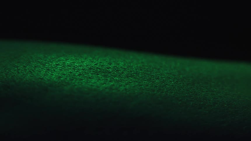 An arm illuminated by green light in closeup has goosebumps
