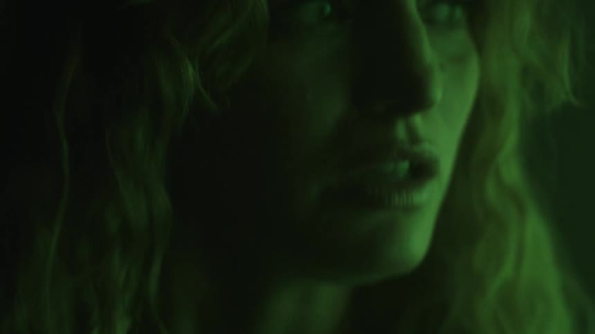 The woman is very afraid in the dark room