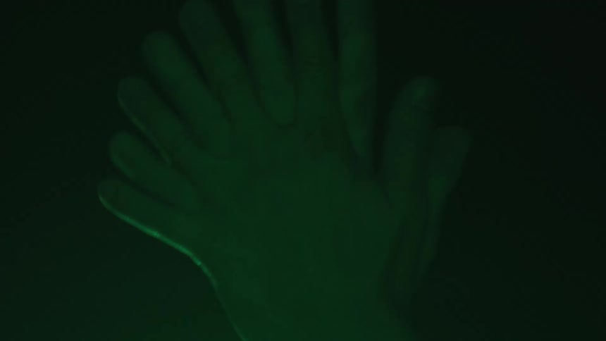 Light illuminating hands moving through different positions together continuously changes color