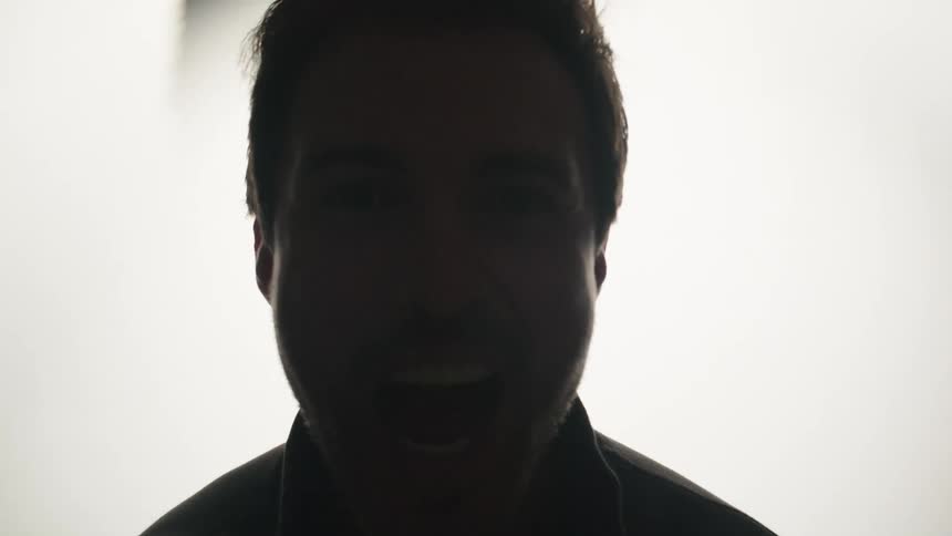 Smiling male silhouette contrasted against a bright white background