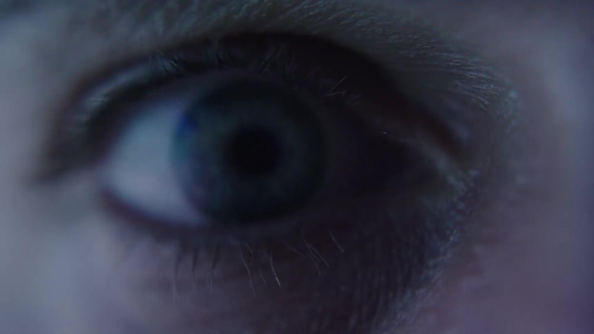 A close view of a persons eye shows the iris changing color blinking and twitching