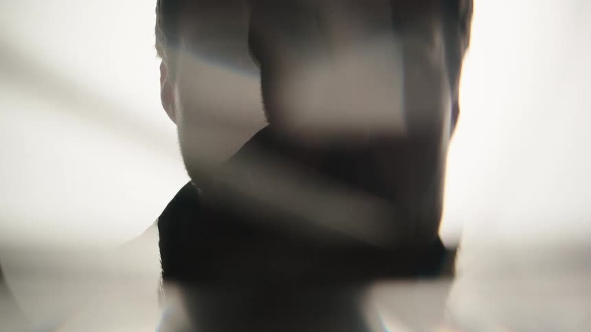 Blurred male silhouette against a bright background
