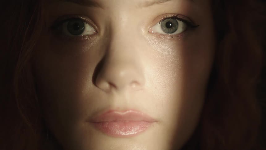 A beam of light passes over the womans face
