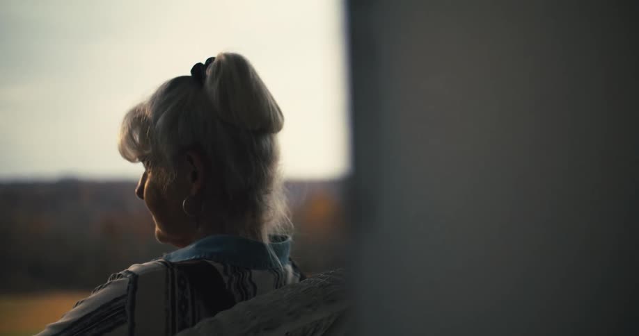 A woman is sitting on a chair on her porch