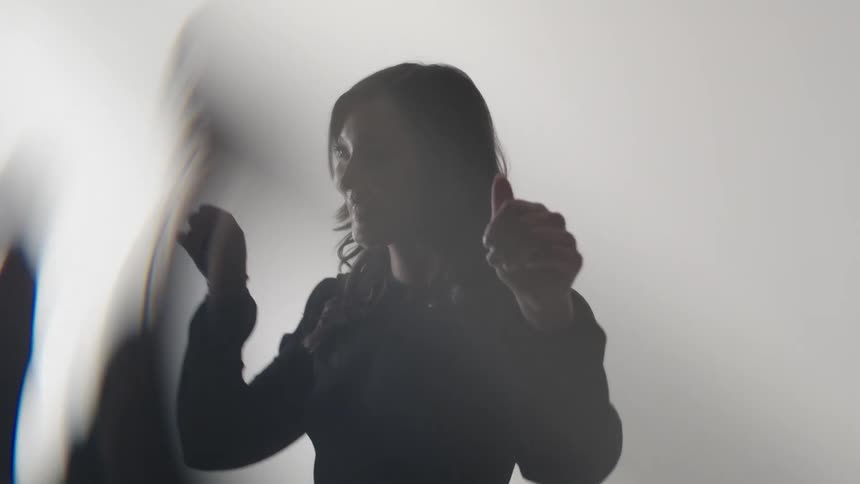 The woman dances and reaches her arms out