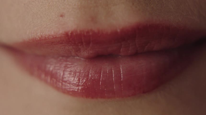 A young woman smiles wearing red lipstick