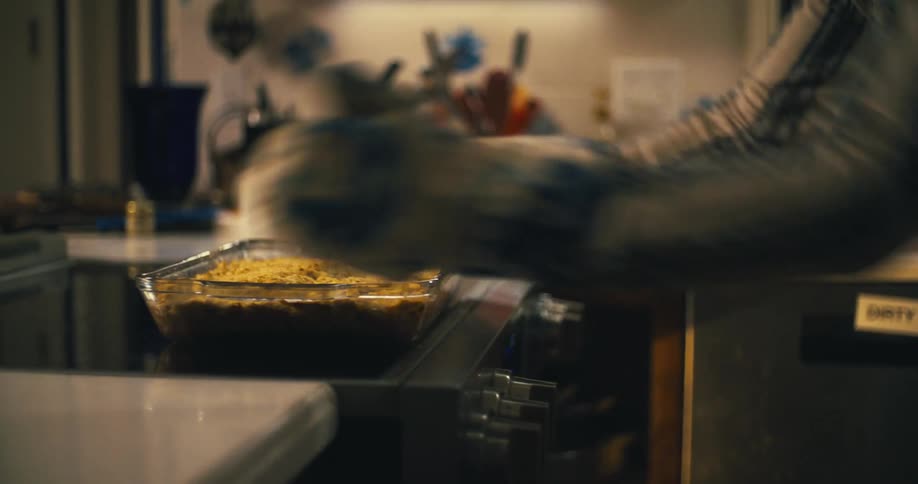 A person takes a casserole from the oven
