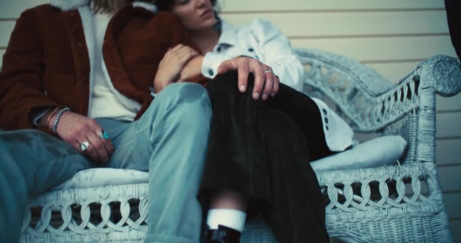 Couple sitting on a porch bench snuggles in an embrace