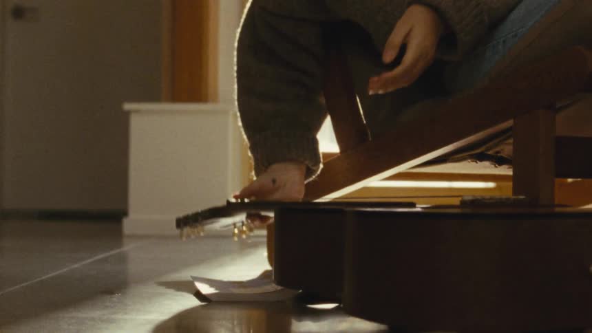 The person puts down the guitar