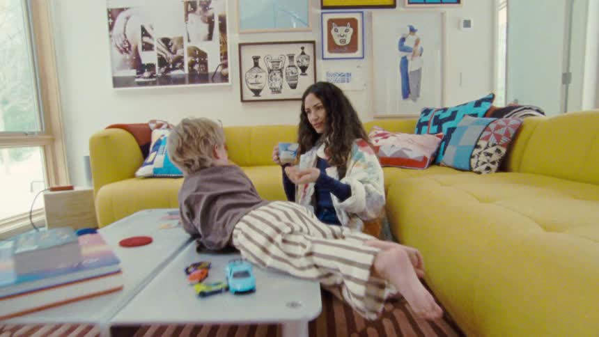 Woman interacts with a child lying on the table in a colorful room