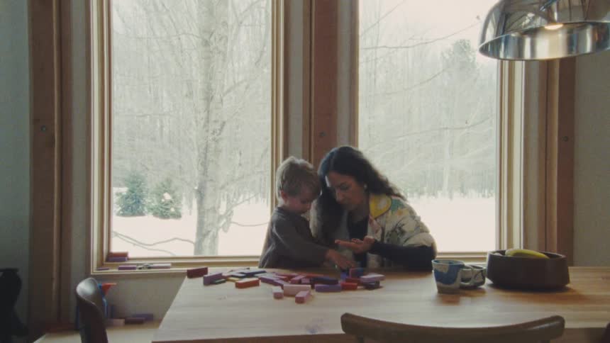 A mother and son play with blocks at home
