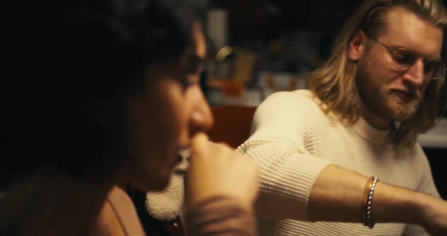Man with glasses serves a woman while they share a meal