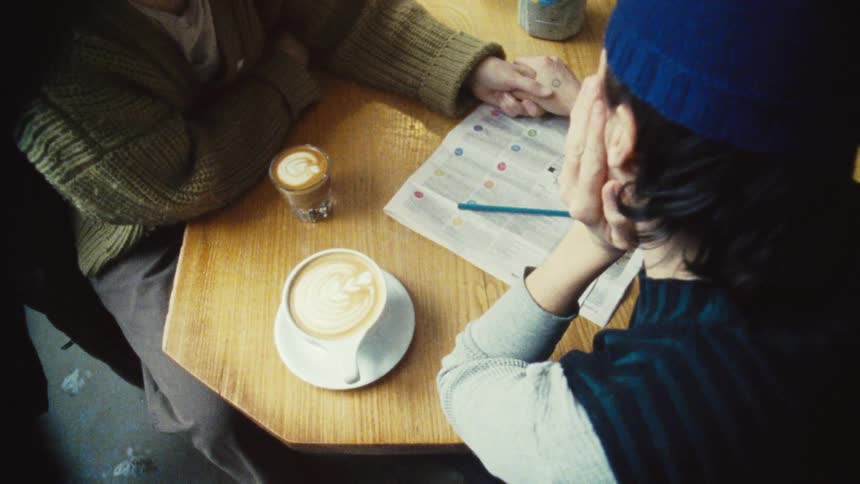 Overhead of a couple at a coffee shop having a latte and an espresso